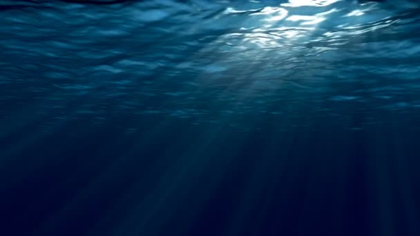 Donker blauwe zee-oppervlak gezien vanaf onderwater. Abstract golven onderwater en stralen van het zonlicht schijnt door.  - Video