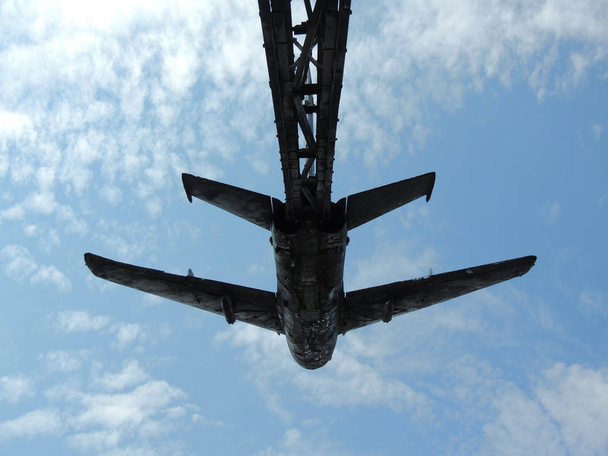 Savaş uçağı anıtın bir mavi gökyüzünde bulutlar üzerinde düşük bakış açısı - Fotoğraf, Görsel