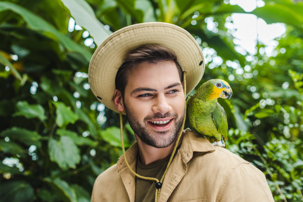 handsome young man with parrot on shoulder - Φωτογραφία, εικόνα