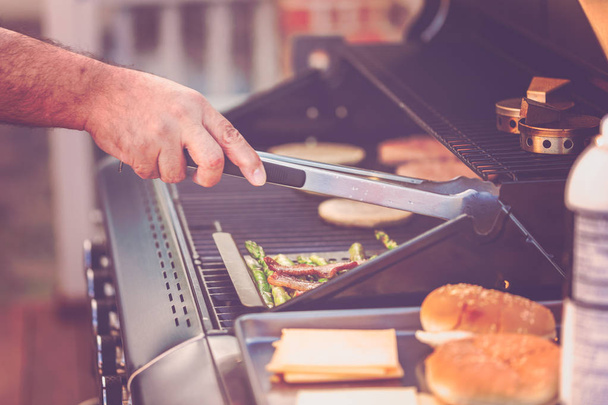Step by step. Cooking burgers on outdoor gas grill in the Summer. - Fotó, kép
