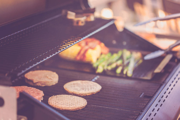 Krok za krokem. Vaření na venkovní plynový gril hamburgery v létě. - Fotografie, Obrázek