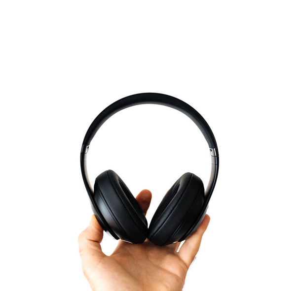 Άνθρωπος που κρατά ασύρματο bluetooth ακουστικά μαύρα - Φωτογραφία, εικόνα