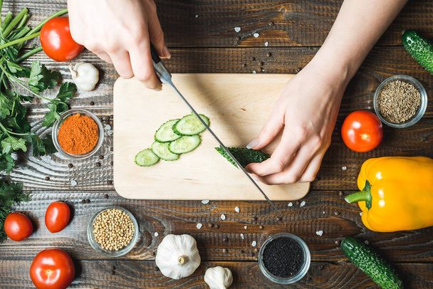 Dámské ruce snížit okurka, rajčata, paprika a česnek - Fotografie, Obrázek