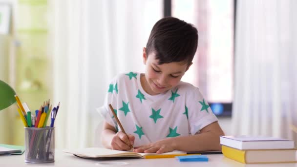 boy with notebook and pencils drawing at home - Video, Çekim