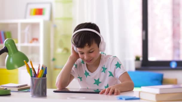 little boy with tablet pc and headphones at home - Felvétel, videó