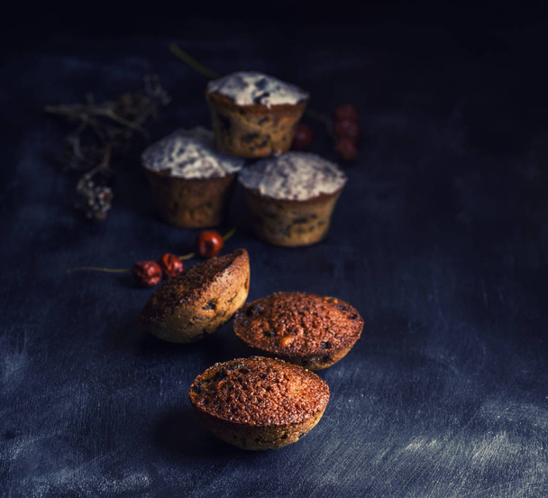 baked round muffins with a raisin black wooden table, close up - Photo, image