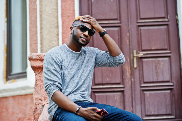 Stylish african american boy on gray sweater and black sunglasse - 写真・画像