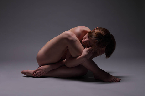 nude beautiful female body on a dark background - Photo, Image