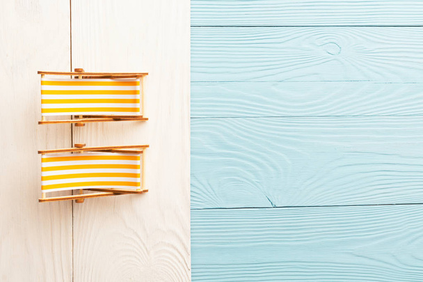 Пляжная миниатюра из разноцветных деревянных подставок и солнцезащитных кресел
 - Фото, изображение