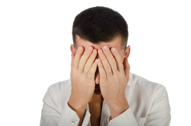 Young handsome guy covers his face with his hands. Business and stress. Office worker. Problems at work - Photo, Image