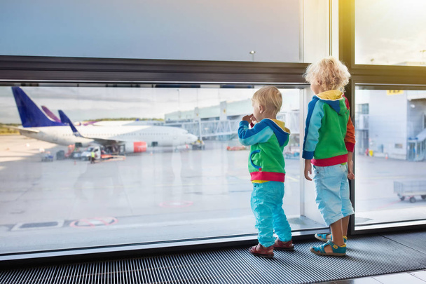 Τα παιδιά ταξιδεύουν και να πετάξει. Παιδί στο αεροπλάνο στο αεροδρόμιο - Φωτογραφία, εικόνα