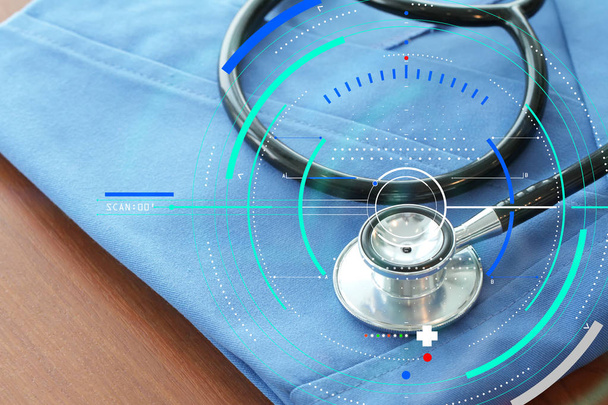 Stethoskop mit blauem Arztkittel auf Holztisch und Rückenlehne - Foto, Bild