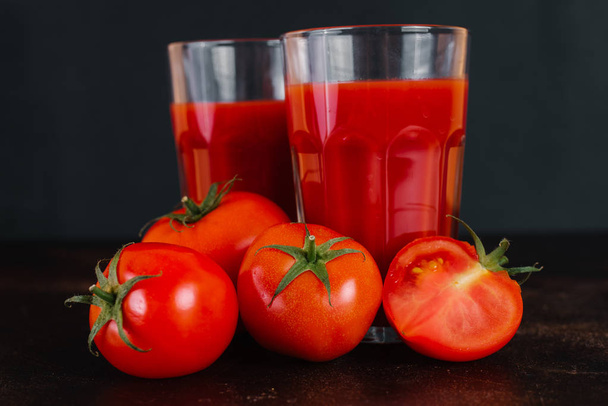 Jugo de tomate fresco y tomates en una mesa de madera
 - Foto, Imagen