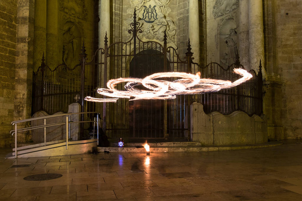 Художники жонглируют двумя горящими поями на пожаре. Длительное воздействие, вызывающее окраску светом
 - Фото, изображение
