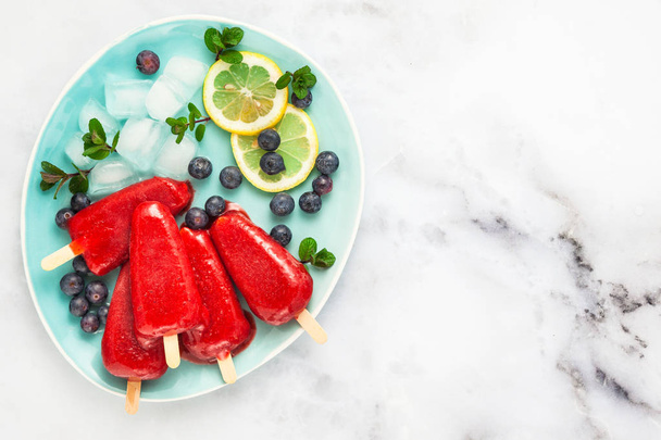 frozen strawberry juice snack ice pop or popsicle on a white mar - Foto, imagen