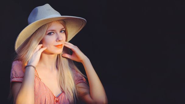 Beautiful young woman in pink dotted summer dress and sun hat po - Photo, Image