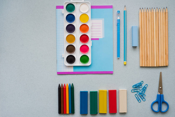 Sobre un fondo azul, accesorios escolares y un bolígrafo, lápices de colores, un par de brújulas, un par de brújulas, un par de tijeras
, - Foto, Imagen