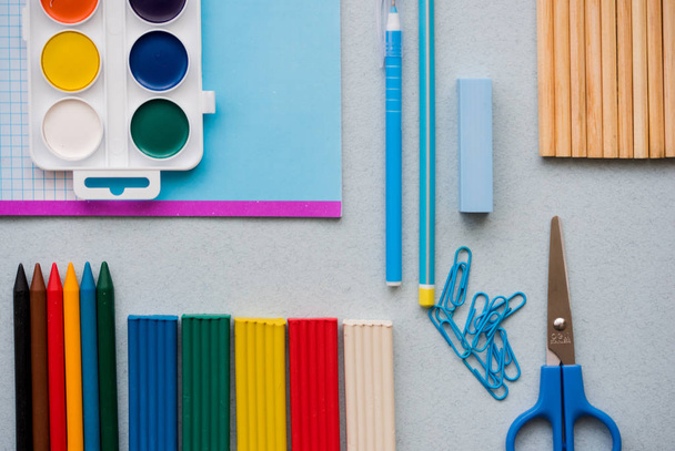 Μπλε φόντο, ΣΧΟΛΙΚΑ ΕΙΔΗ και ένα στυλό, χρωματιστά μολύβια, ένα ζευγάρι των πυξίδες, ένα ζευγάρι των πυξίδες, ψαλίδι, - Φωτογραφία, εικόνα