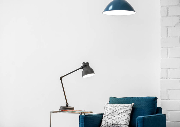 Modern lamps with blue armchair indoors - Fotografie, Obrázek