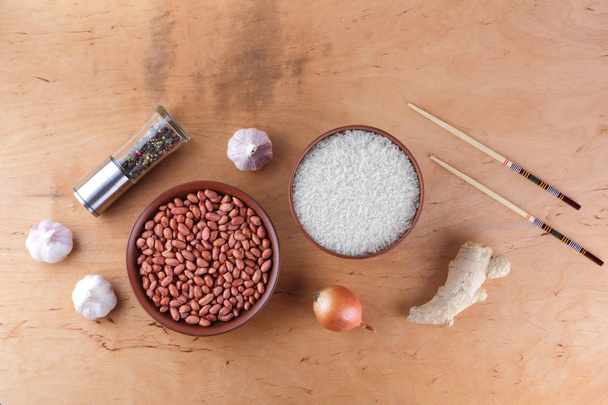 Chinese raw food ingredients, nuts, vegetables, ginger root. Chinese dishes are most popular all over the world. Raw rice and spices on a wooden background. Garlic and onion for cooking. Copy space - Fotoğraf, Görsel