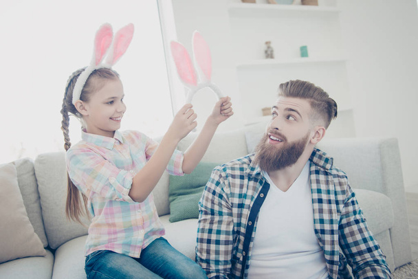 Family with one parent, cute little girl putting on bunny ears t - 写真・画像