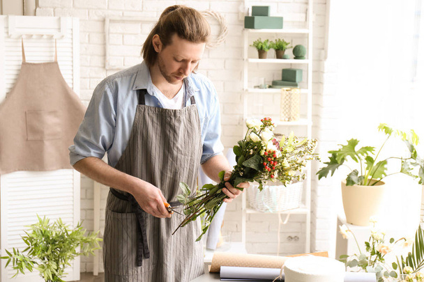 Male florist pruning stems at workplace - Photo, Image