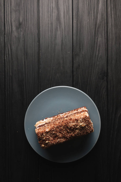 Dessert traditionnel italien tiramisu sur une assiette grise sur un fond en bois noir
. - Photo, image