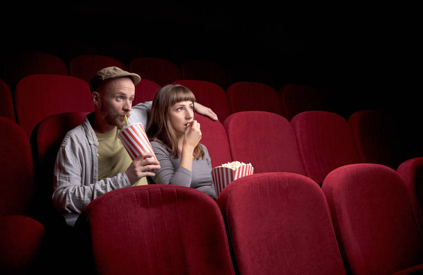 Young couple sitting at red movie theatre - Φωτογραφία, εικόνα