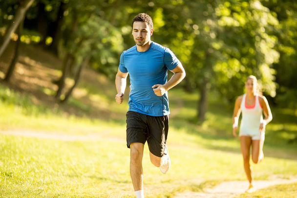 Young couple running in the park on a summer day - Photo, Image