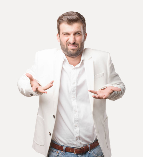 young handsome businessman confused, wearing white blazer, disagree expresion. Person isolated against monochrome background. - Foto, imagen