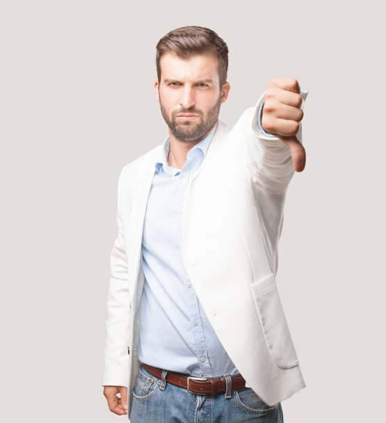 young handsome businessman, white blazer, disagree or sad expression. Person isolated against monochrome background. - Foto, afbeelding