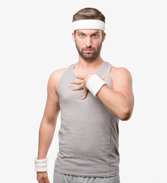 Young handsome sportsman confused with gray tank top. Person isolated against monochrome background. - Fotó, kép