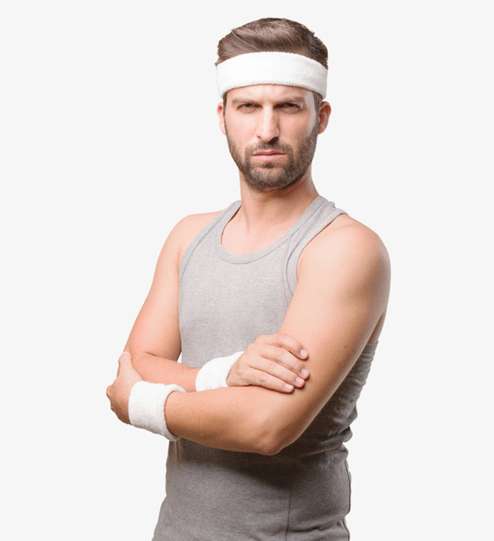 Young handsome sportsman with angry expression, with gray tank top. Person isolated against monochrome background. - Foto, afbeelding