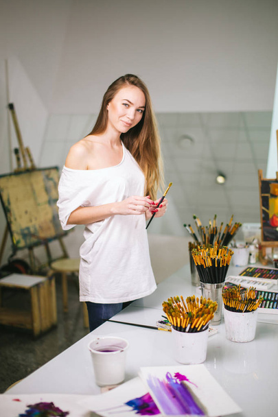 Natural beauty teacher painter in her studio preparing to an art class - Фото, изображение