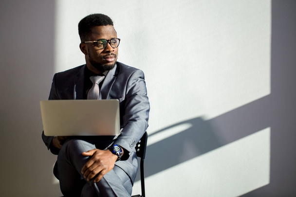 african coworker wearing glasses and using laptop in office - Fotó, kép