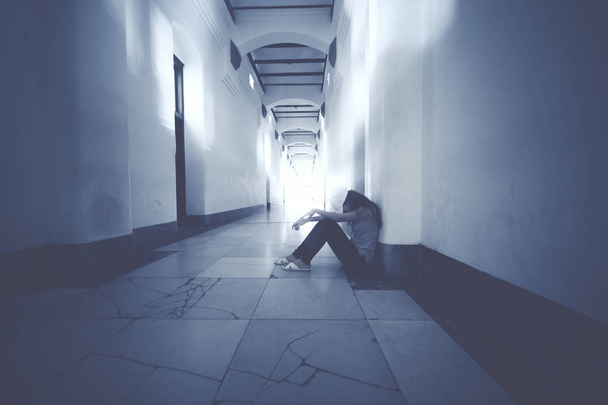 Desperate woman sitting in the corridor - Foto, imagen