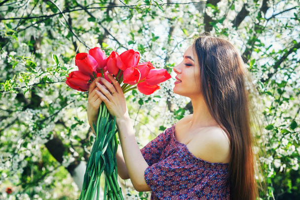 young woman with tulips in a blossoming Park - Φωτογραφία, εικόνα