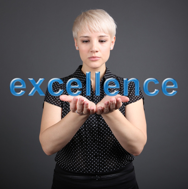 Business woman holding Excellence sign - finance concept - Foto, Bild