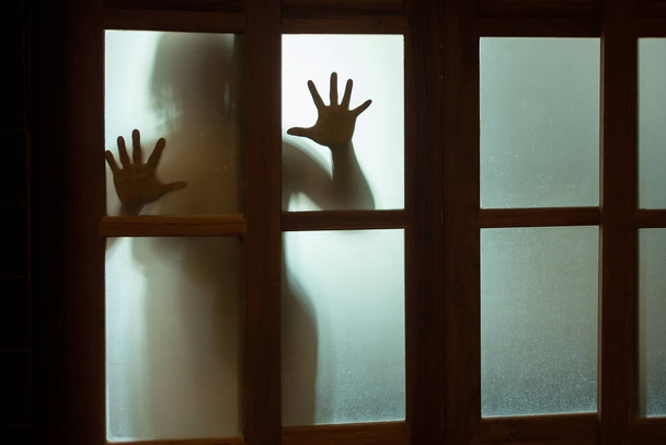 Жахлива жінка за віконним склом у чорно-білому. Розмитість
  - Фото, зображення