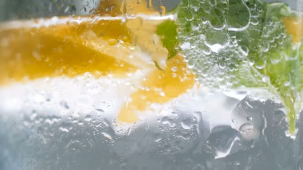 Imágenes en cámara lenta macro de gotas de agua goteando de un vaso de limonada fría
 - Metraje, vídeo