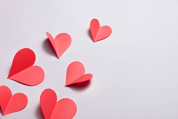 Beautiful red paper hearts on white paper background  - Photo, Image