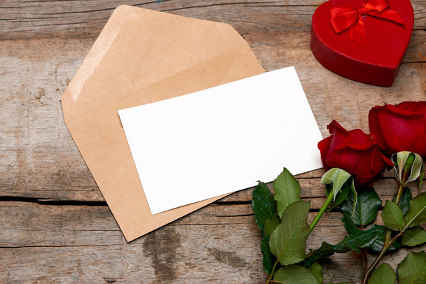 Rose et papier blanc dans une enveloppe sur fond en bois pour la fête des mères
.  - Photo, image