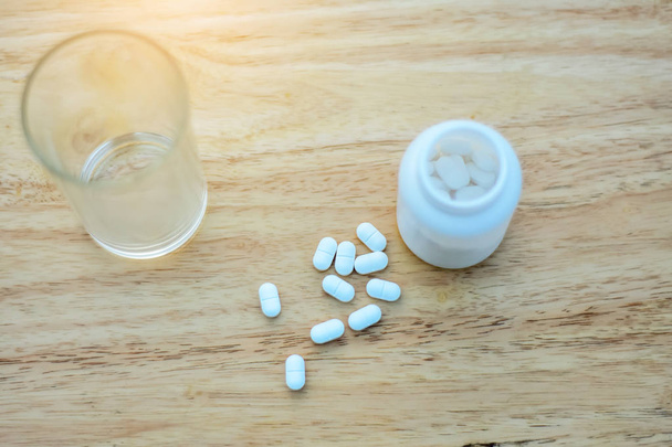 Paracetamol voor het verminderen van koorts wordt geplaatst op de tafel en een glas water is beschikbaar, Paracetamol met water - Foto, afbeelding