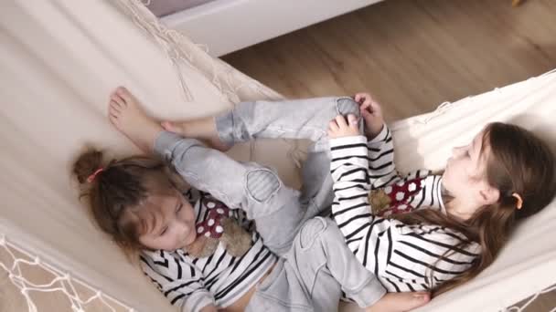 Two cute girls are swinging on the white hammock. Having rest. Slow motion - Video, Çekim