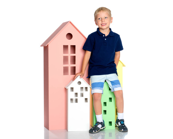 Маленький мальчик играет с красочными домами
. - Фото, изображение
