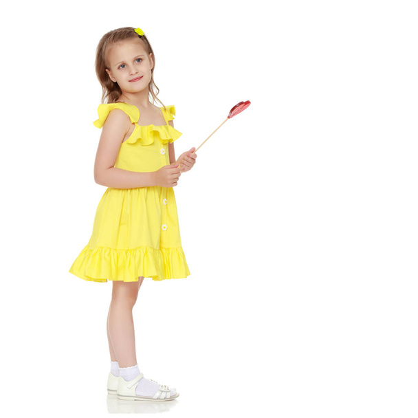 Little girl with a candy on a stick - Фото, зображення