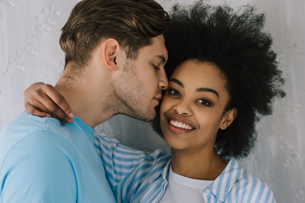 Tedere man omhelzen en kussen van Afro-Amerikaanse vriendin - Foto, afbeelding