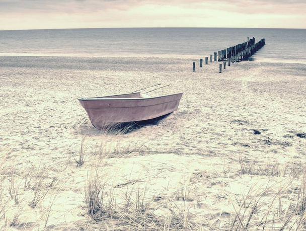 Barco de remo de pesca abandonado na areia da baía do mar. Nível silencioso da água do mar
  - Foto, Imagem