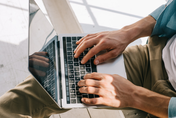 Close-up view of man typing on laptop keyboard on his knees - Foto, Imagem