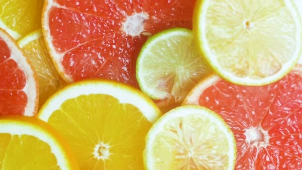 Macro slow motion video of camera moving over assortment of citrus fruits lying on table - Footage, Video